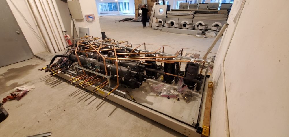 Complex arrangement of pipes and machinery on a construction site. Copper tubing, and black components.