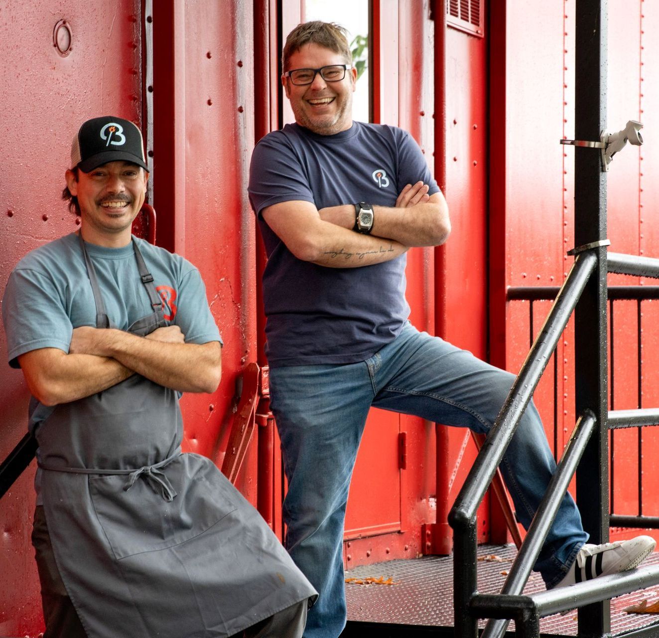 Two men standing next to each other with one wearing a hat with the number 3 on it