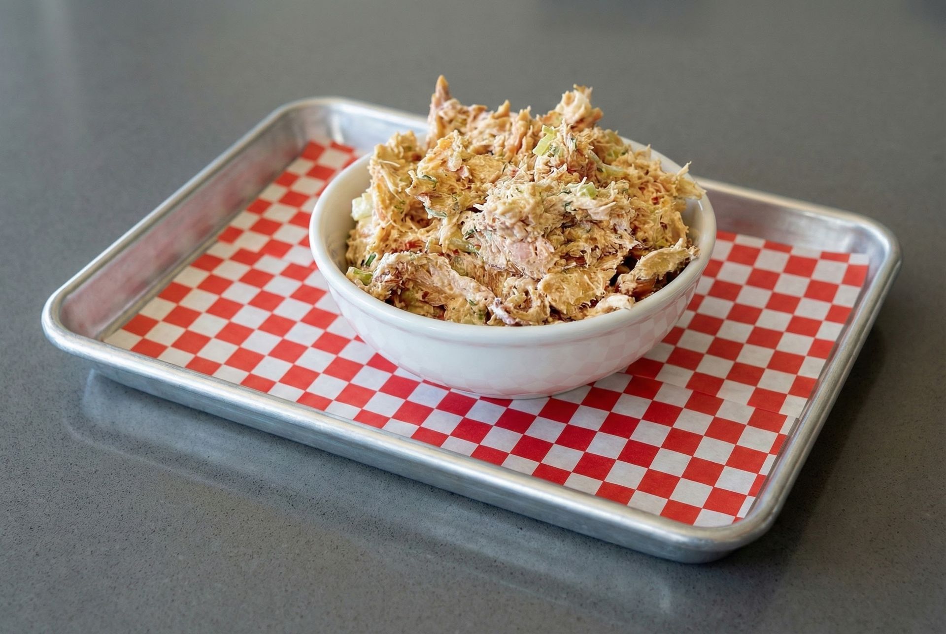 A bowl of food is sitting on a table next to salt and pepper.
