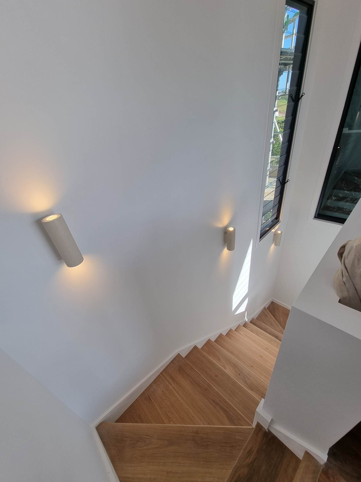 Staircase with wooden steps and white walls — Col Groves Electrics Pty Ltd in Ballina, NSW