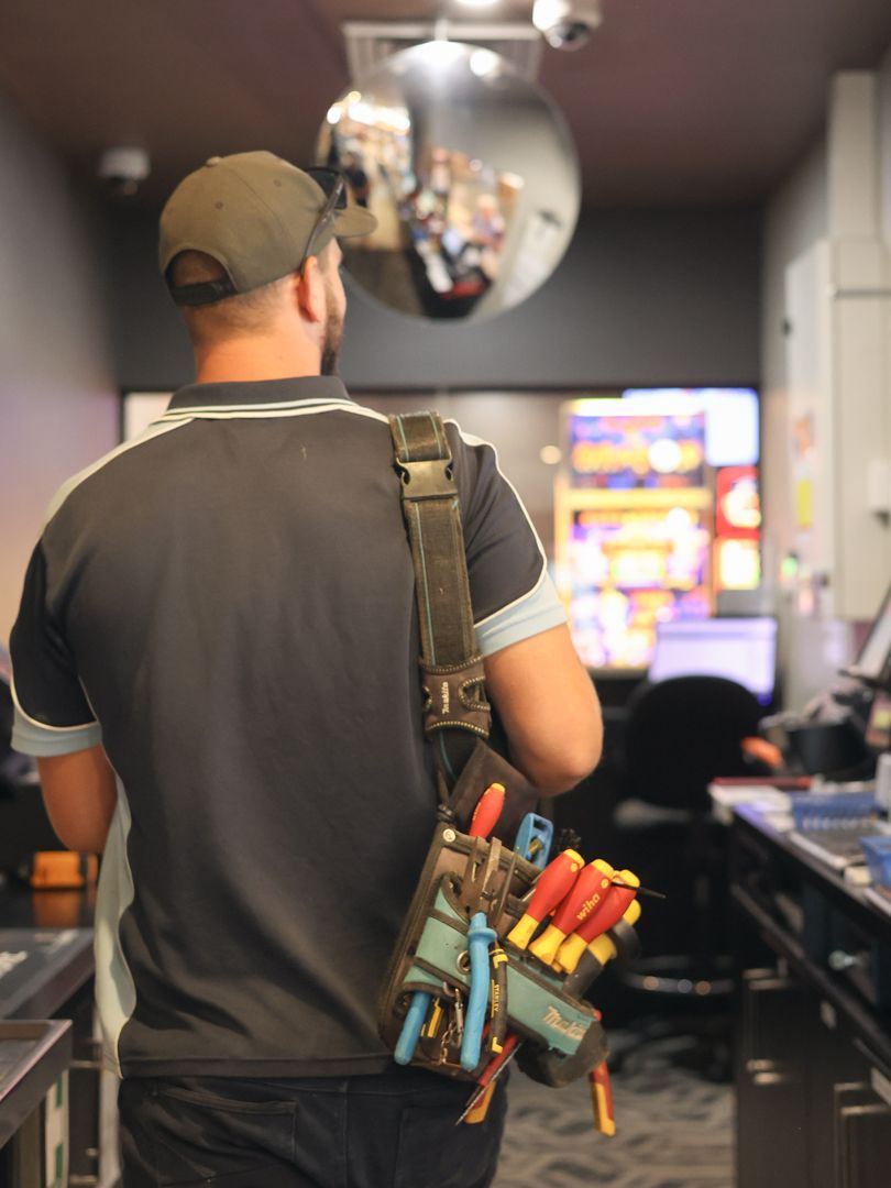 Electrician walks into a room, tools in a belt slung over his shoulder — Col Groves Electrics Pty Ltd in Ballina, NSW