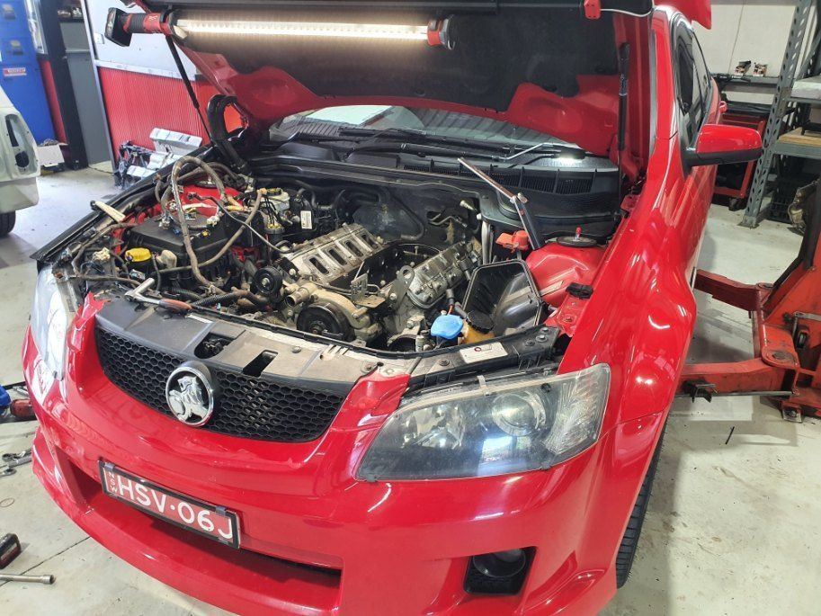 A Red Car With the Hood Up is Being Worked on — All Care Car Services Kumho Tyre Platinum Dealer in Kurri Kurri, NSW
