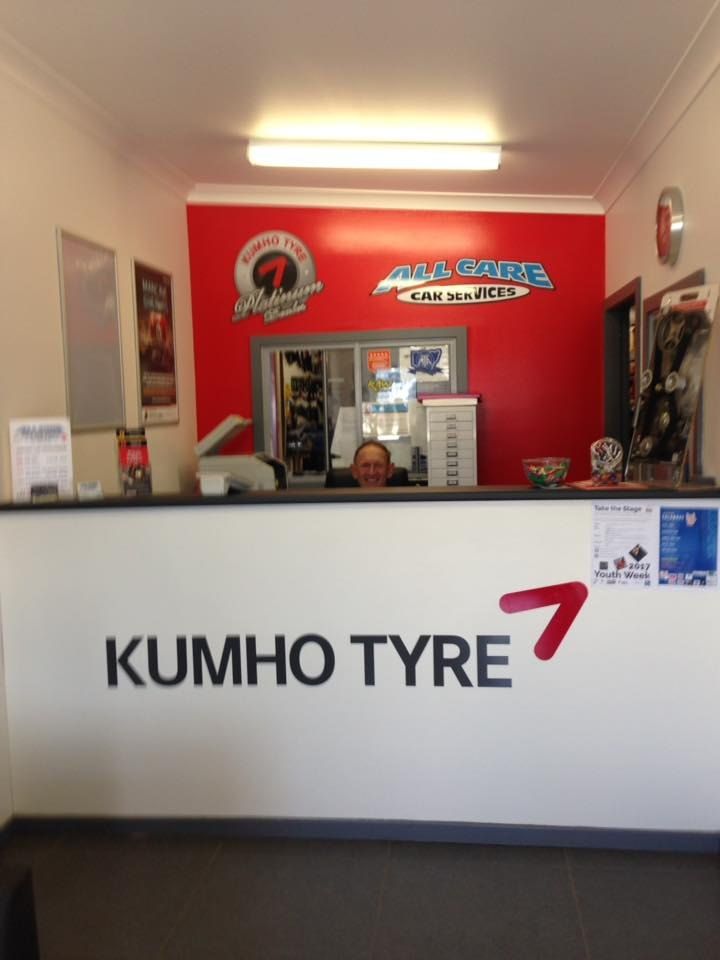 A Man Stands Behind a Counter That Says Kumho Tyre 7 — All Care Car Services Kumho Tyre Platinum Dealer in Kurri Kurri, NSW