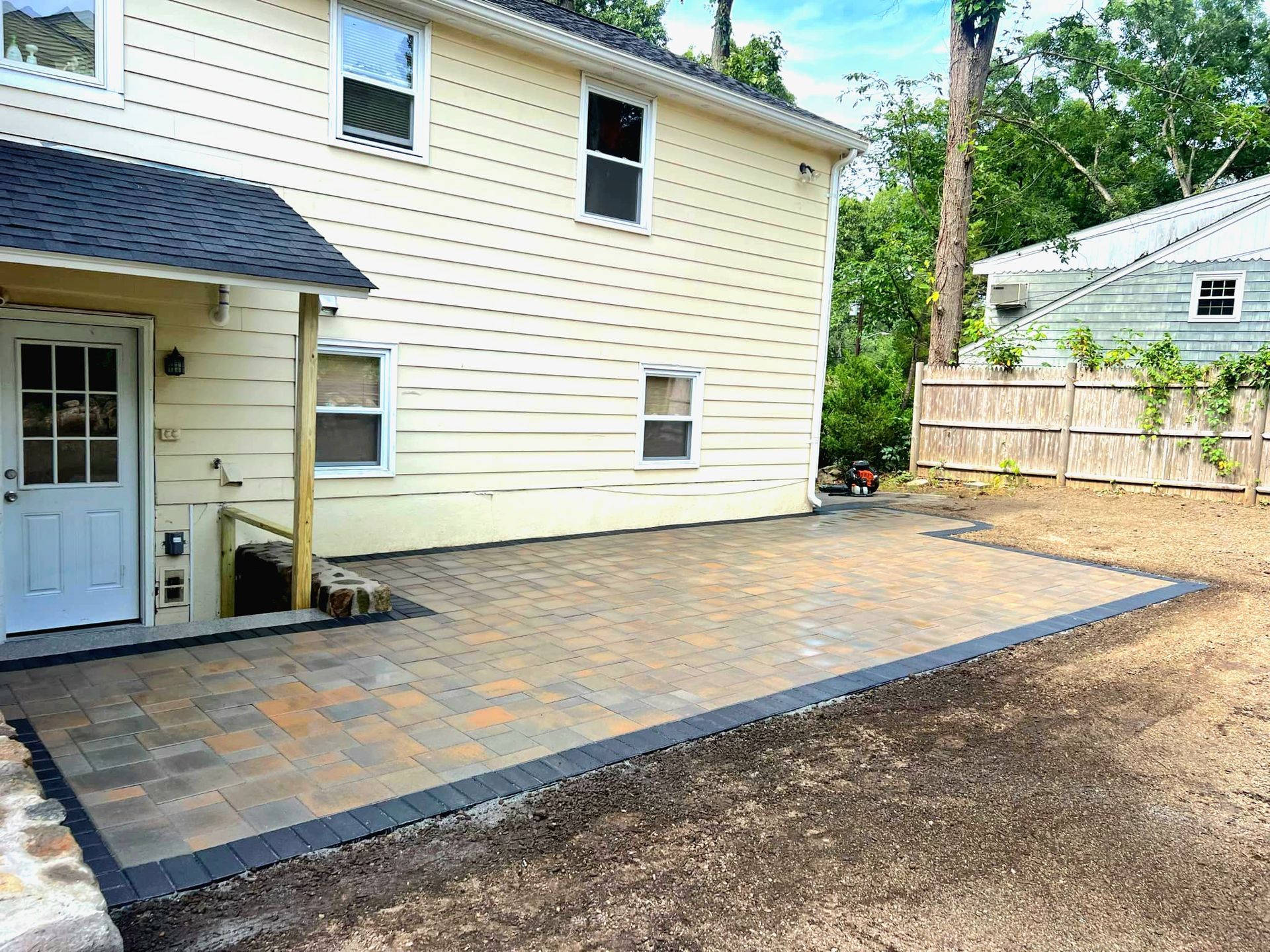 Stone patio with steps and retaining wall to expand useable yard space