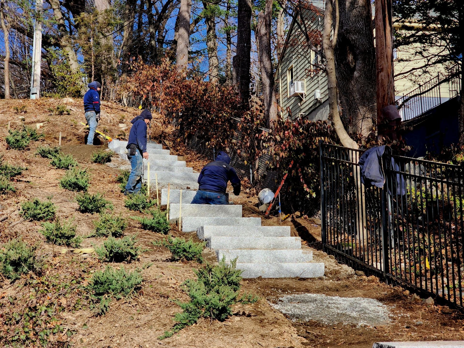 Landscapers building a stone stair way up a back yard slope