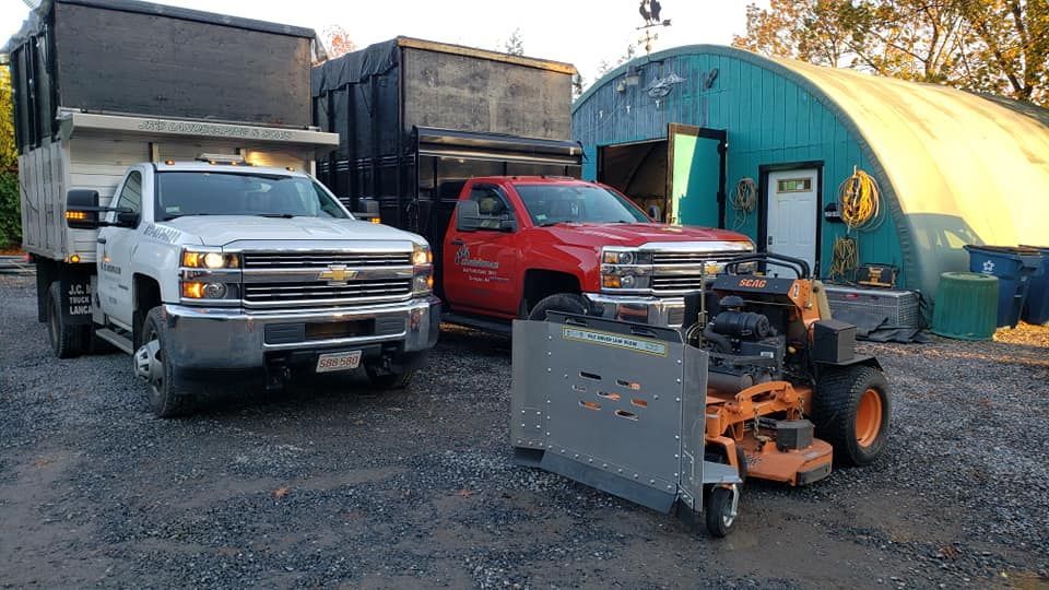 Two trucks trucks with leaf boxes on them and a SCAG mower with a leaf plow on it ready for fall cleanups!
