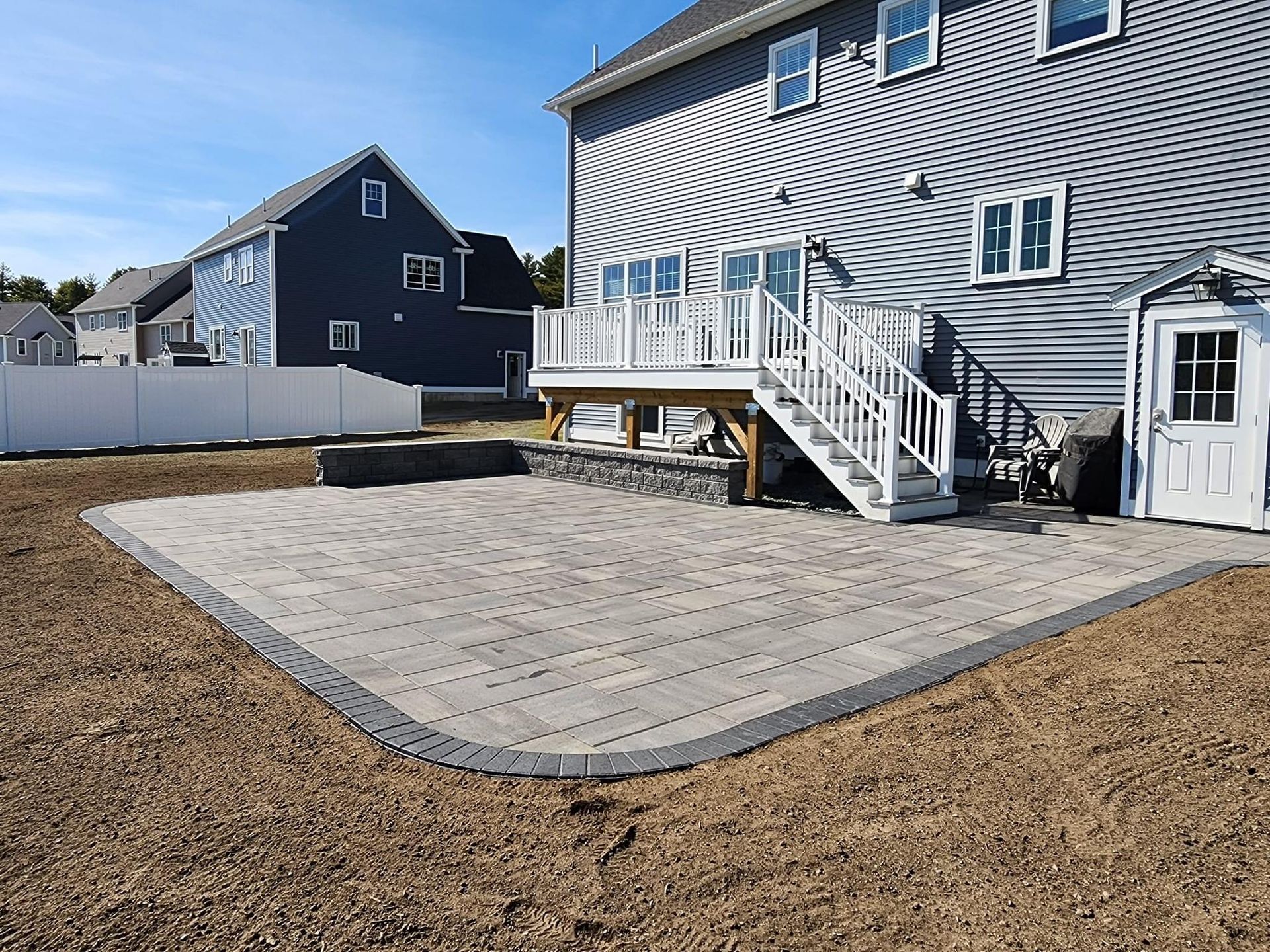 Rounded patio installation. Professional patio installation in Burlington, MA. New patio and wall built in backyard 