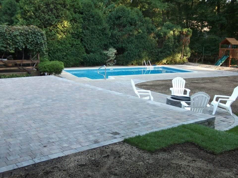 Hardscaping project in Massachusetts. Patio project by the pool. Outdoor firepit installation in Burlington.
