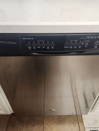 A close up of a stainless steel dishwasher in a kitchen.