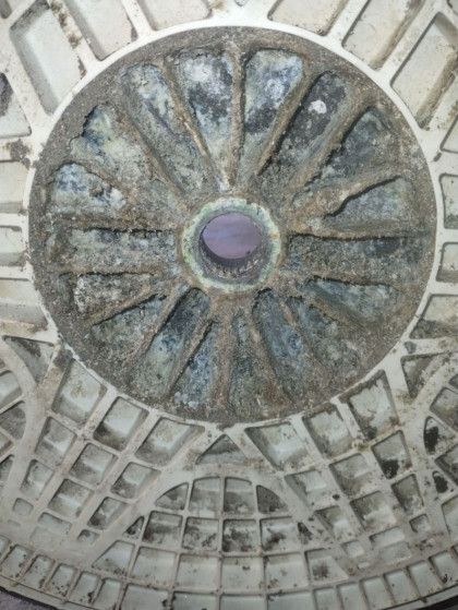A close up of a manhole cover with a circular design on it.