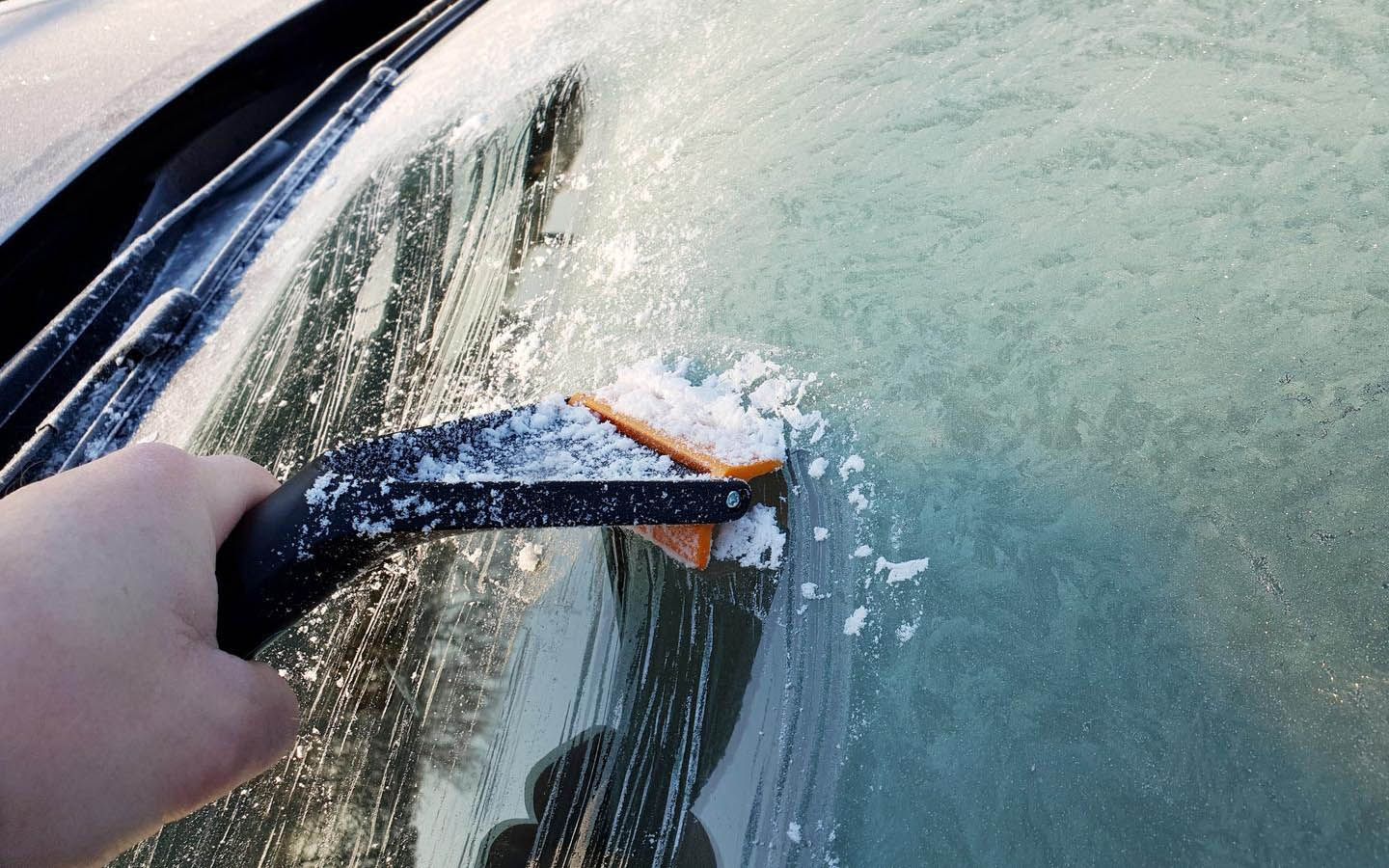 A person is deicing their windscreen 