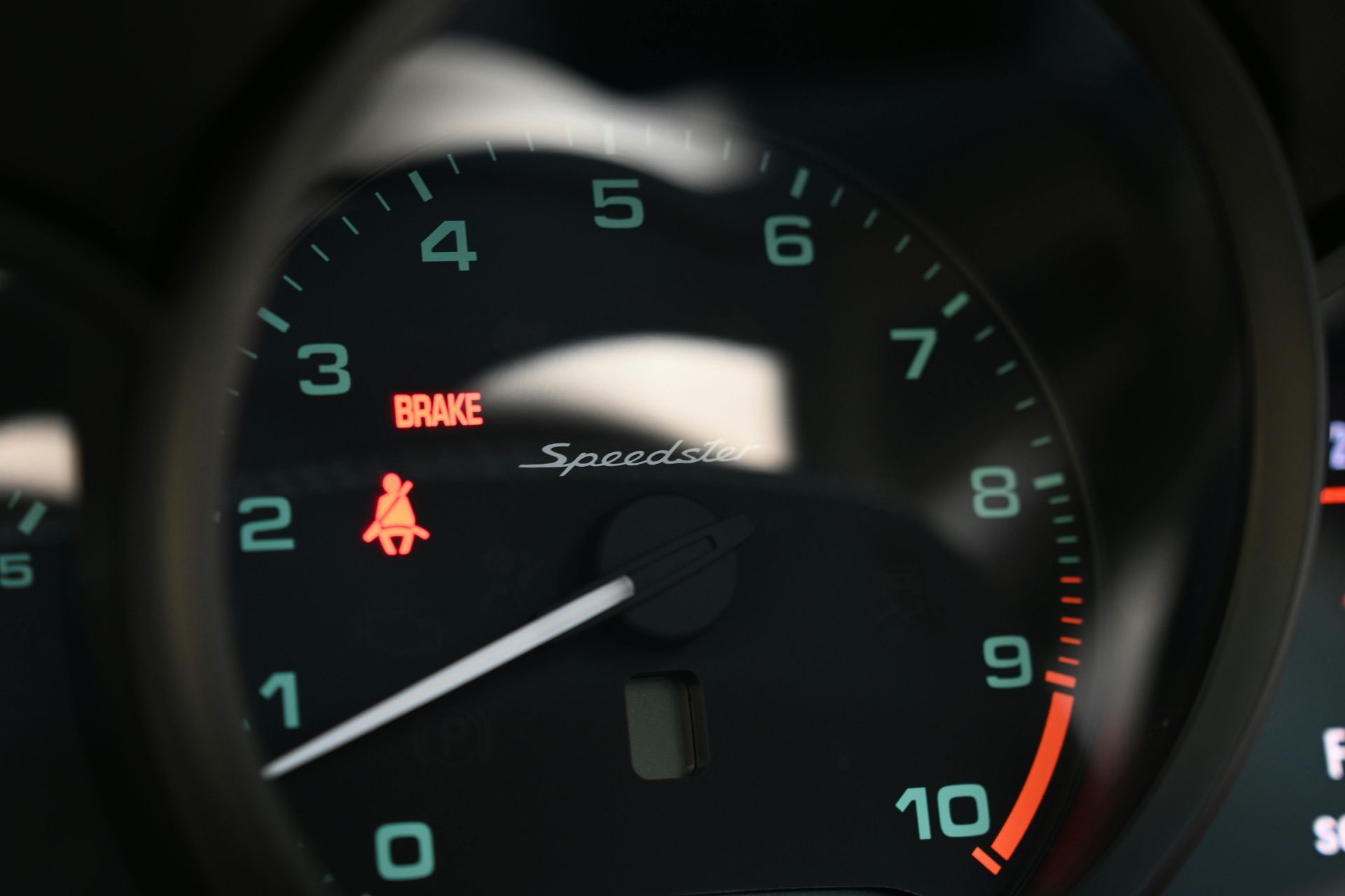 A close up of a brake light on a speedometer