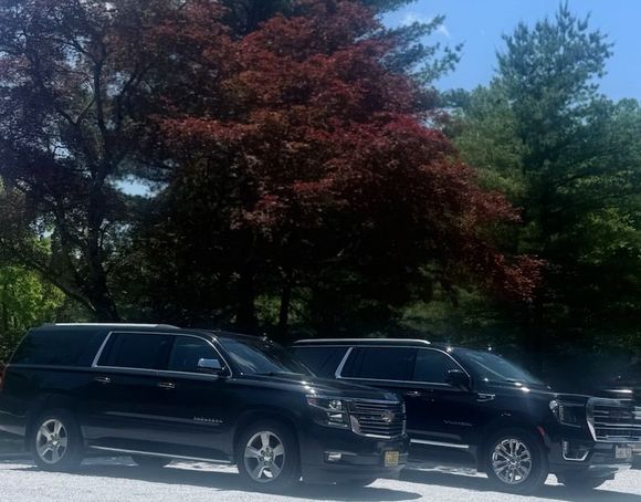Two black suvs are parked next to each other in a parking lot.