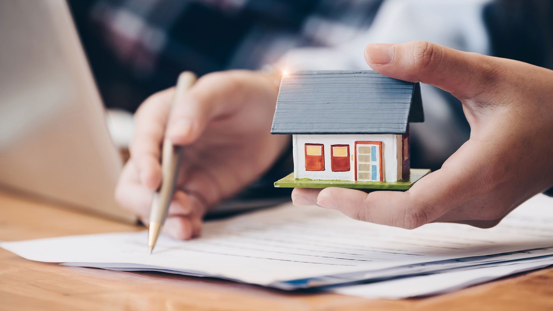 Holding a Miniature House While Writing — Oakland, CA — Law Offices of Mark E Rubke