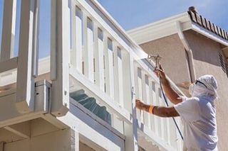 Man spray painting deck — Exterior Painting in Salem, OR