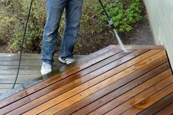 Man pressure washing wooden floor — Pressure Washing in Salem, OR