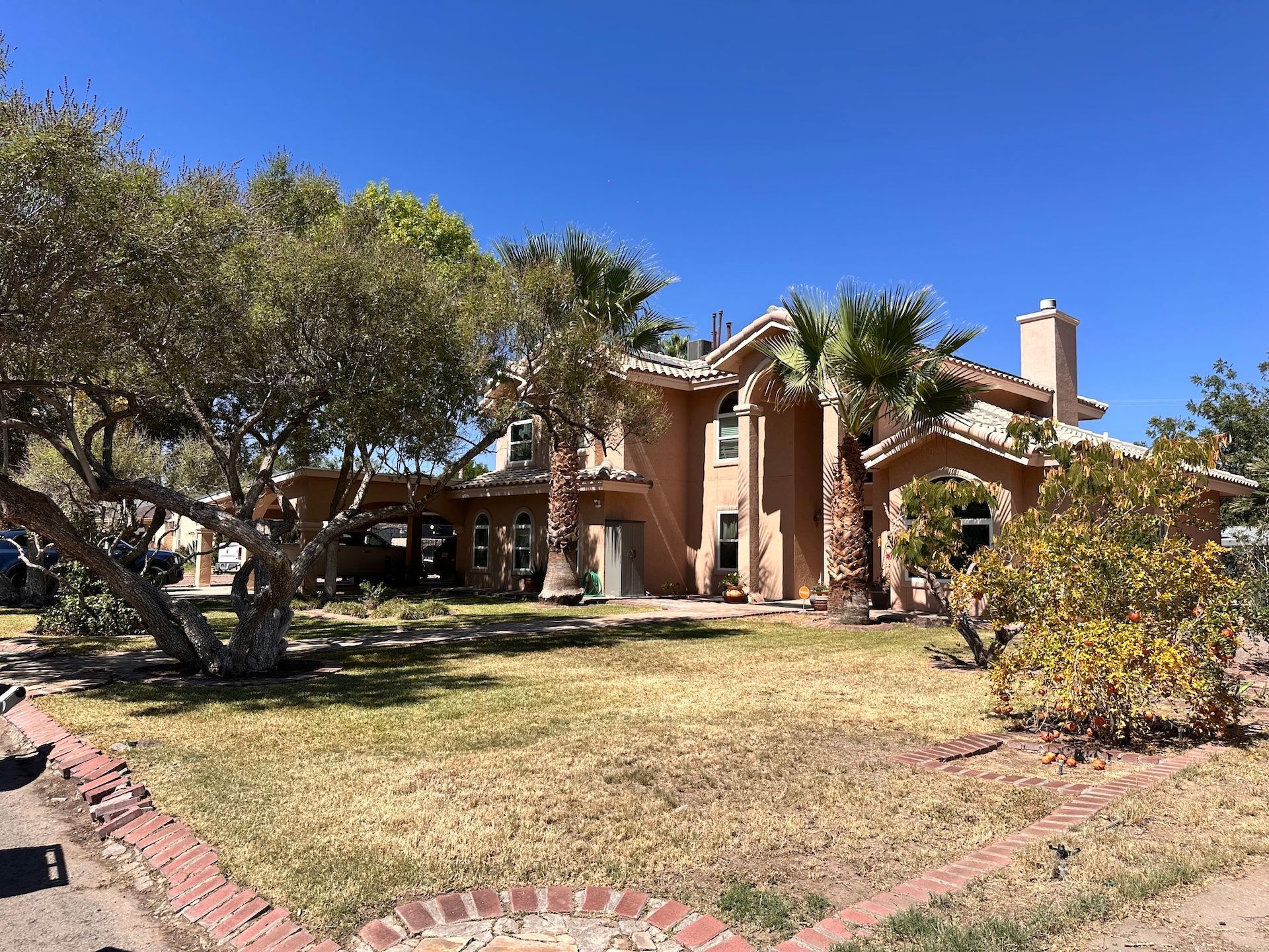 A beautiful large house with a lot of trees in front of it.