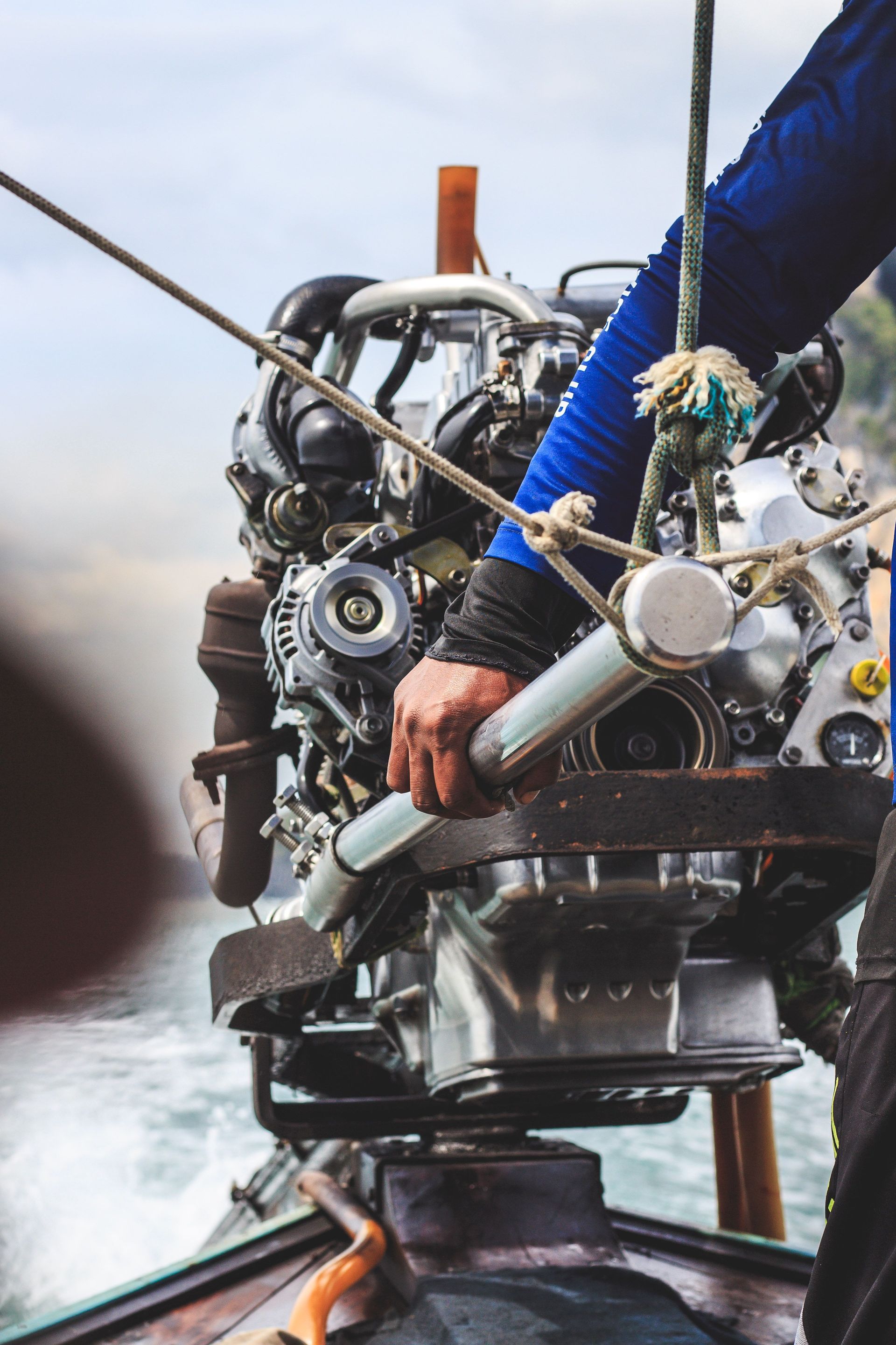 Person steering a rope-lift machine, hands on gears and cables in a misty outdoor setting