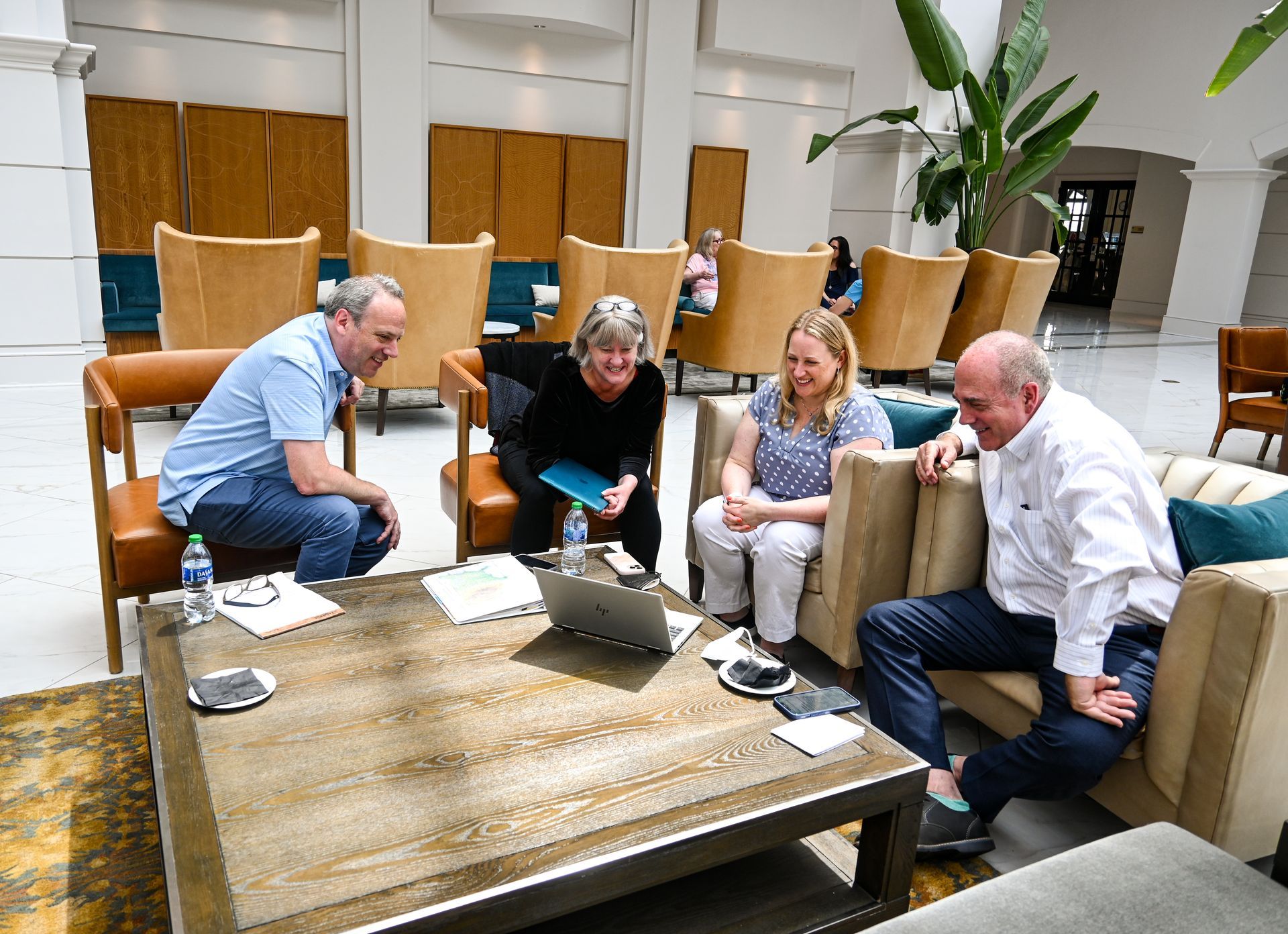 A group of people are sitting around a table in a living room.