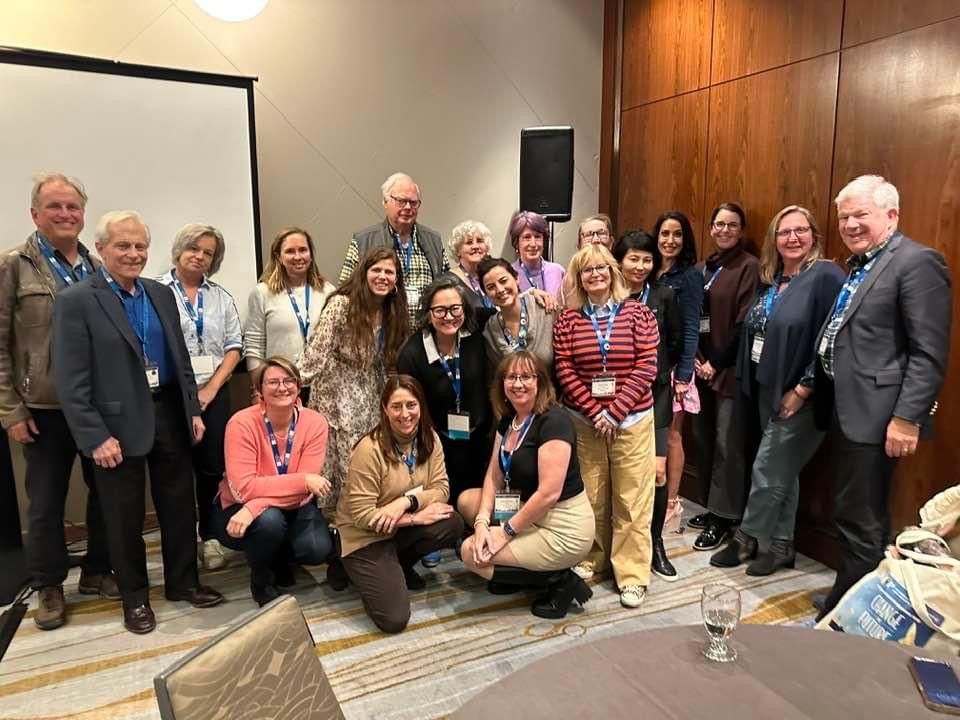 A group of people are posing for a picture in a room.
