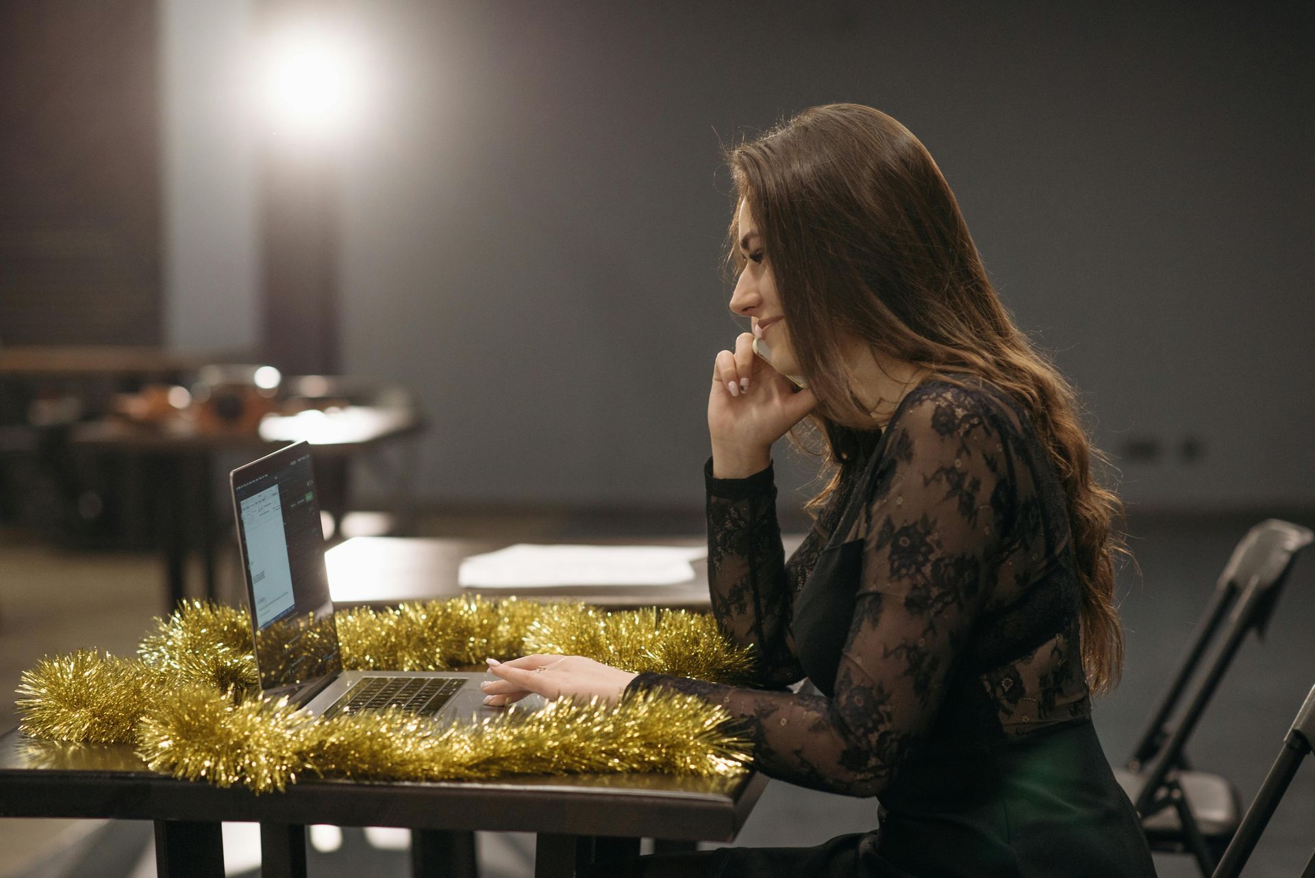 A woman is giving a presentation to a group of people in front of a projector screen.