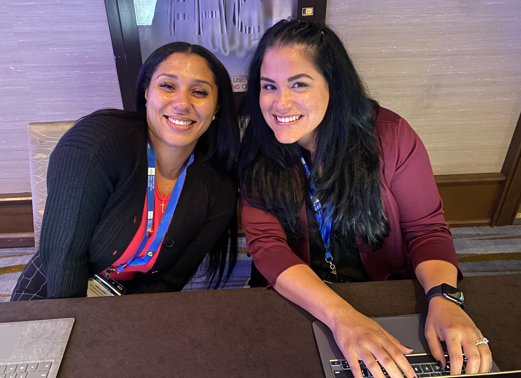 Three women are sitting on a set of stairs talking to each other