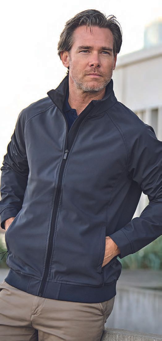 Ένας άντρας που φοράει μπλε μπουφάν στέκεται με τα χέρια στις τσέπες του.