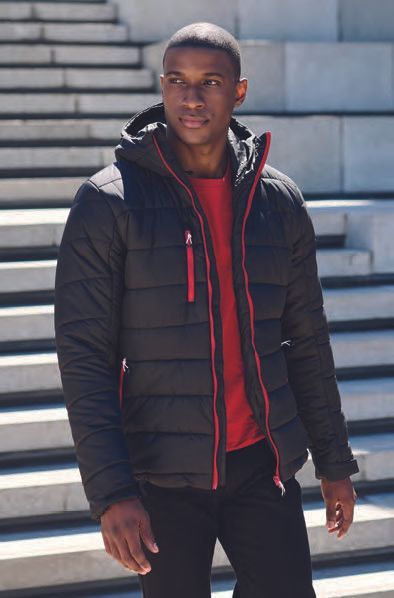 Ένας άντρας που φοράει μαύρο σακάκι και κόκκινο πουκάμισο στέκεται στις σκάλες.