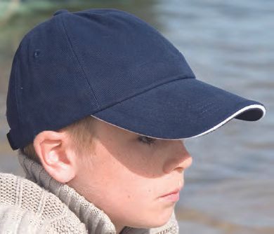 Ένα νεαρό αγόρι που φοράει ένα μπλε καπέλο του μπέιζμπολ με λευκό τελείωμα