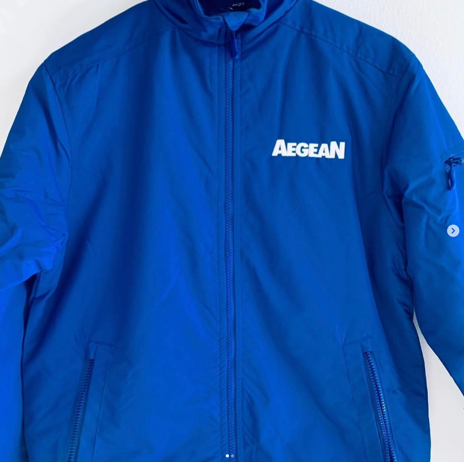 Ένα μπλε αιγαιοπελαγίτικο σακάκι κρέμεται σε έναν λευκό τοίχο