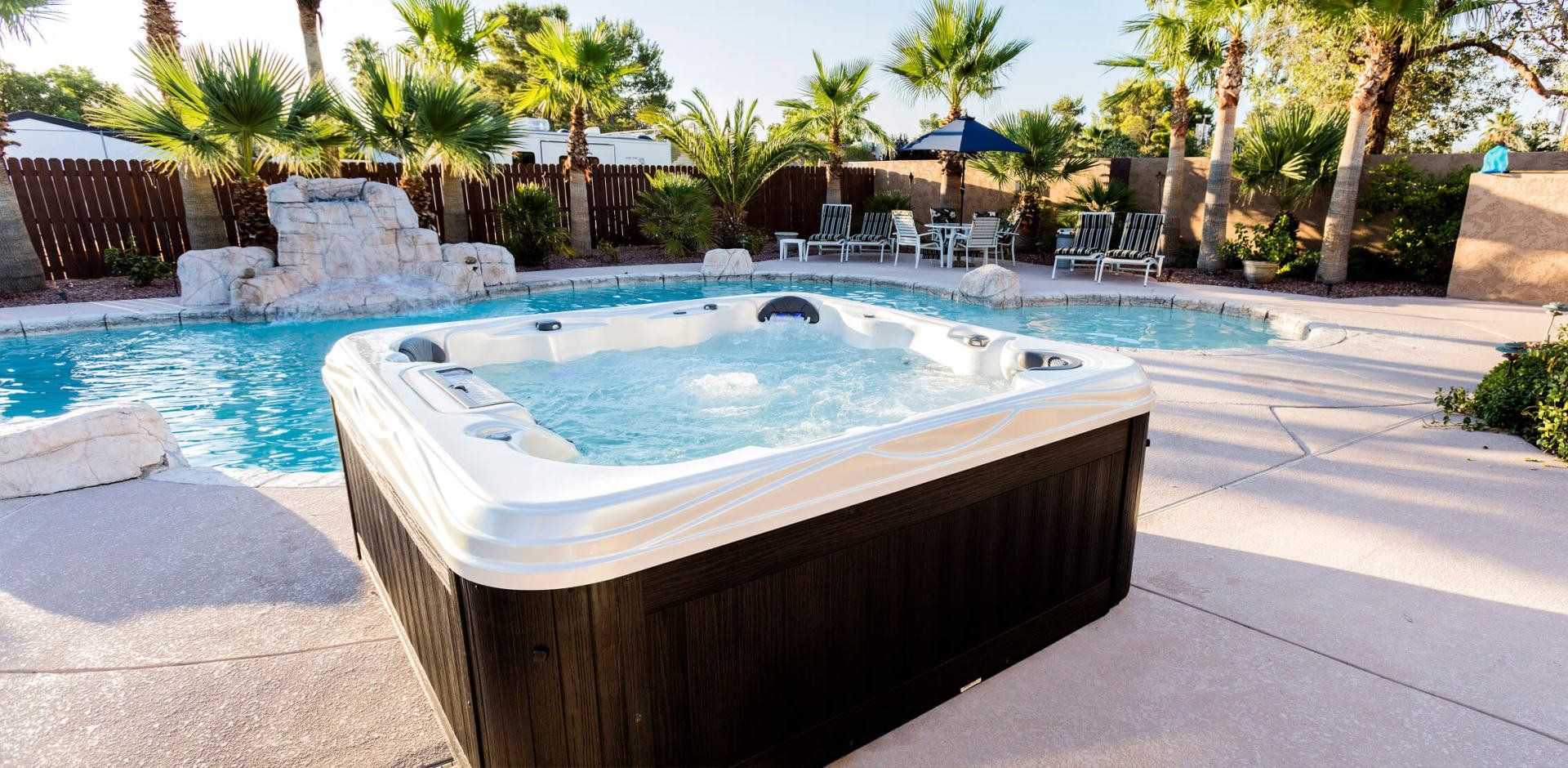 A hot tub is sitting next to a swimming pool.