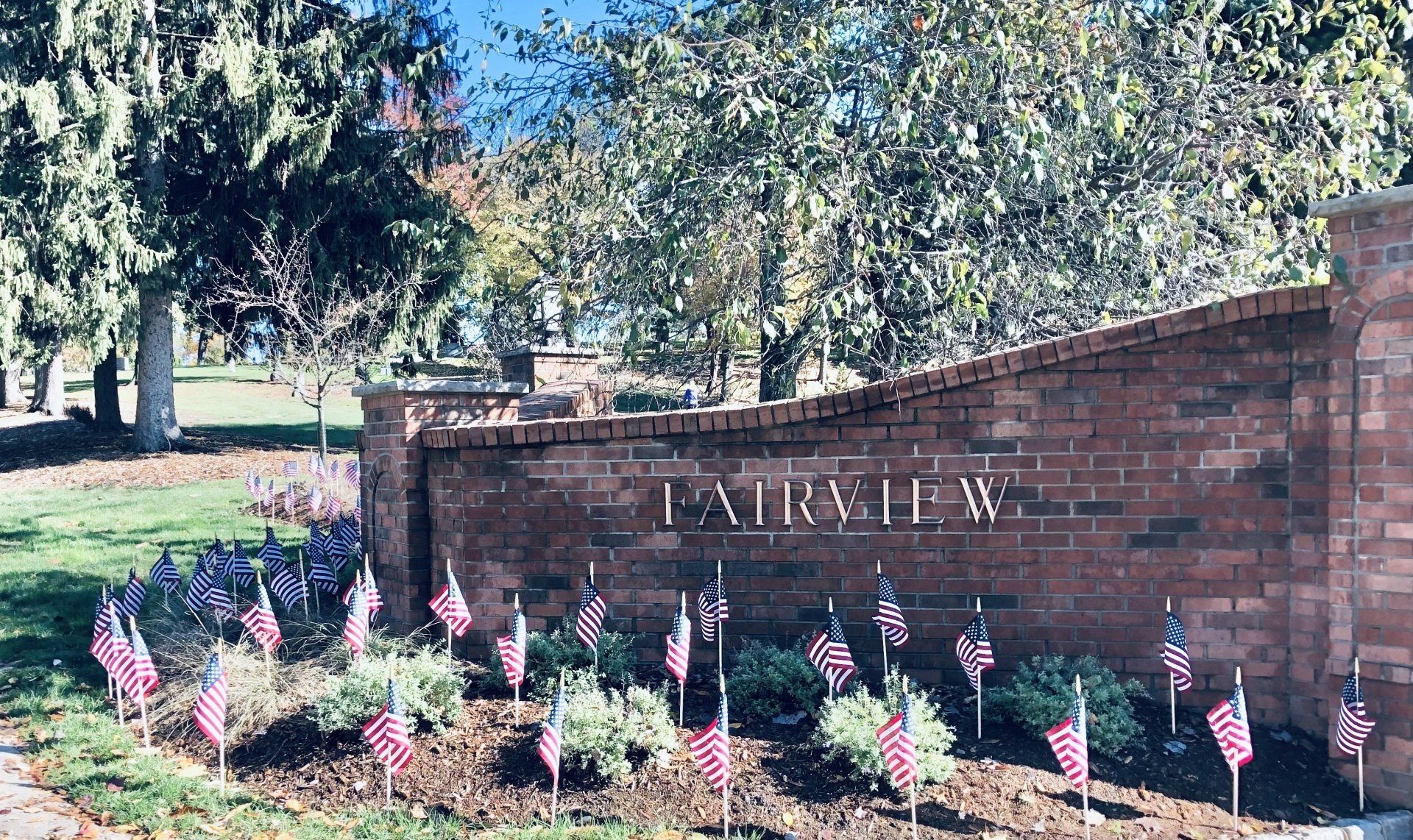 A brick wall with a lot of american flags in front of it.