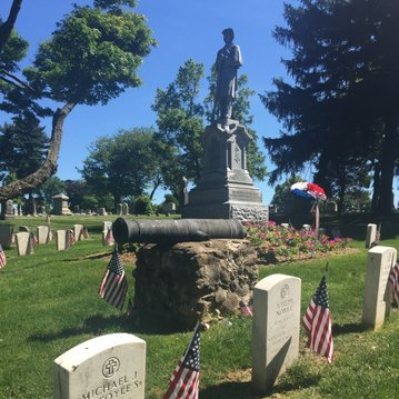 A cemetery with a cannon and a statue of a man
