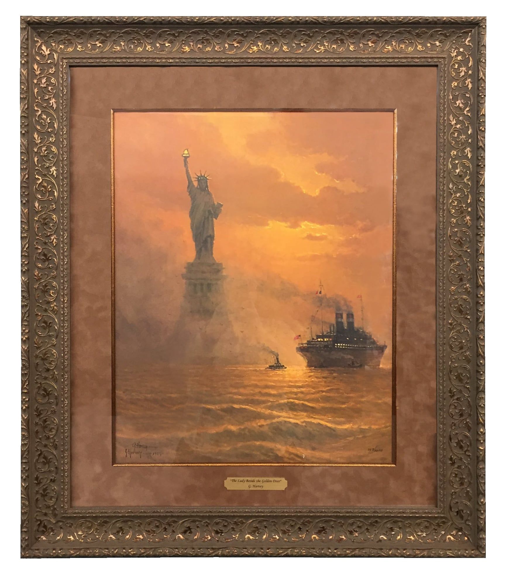 Painting of Statue of Liberty with ship at sunset, framed in ornate gold.