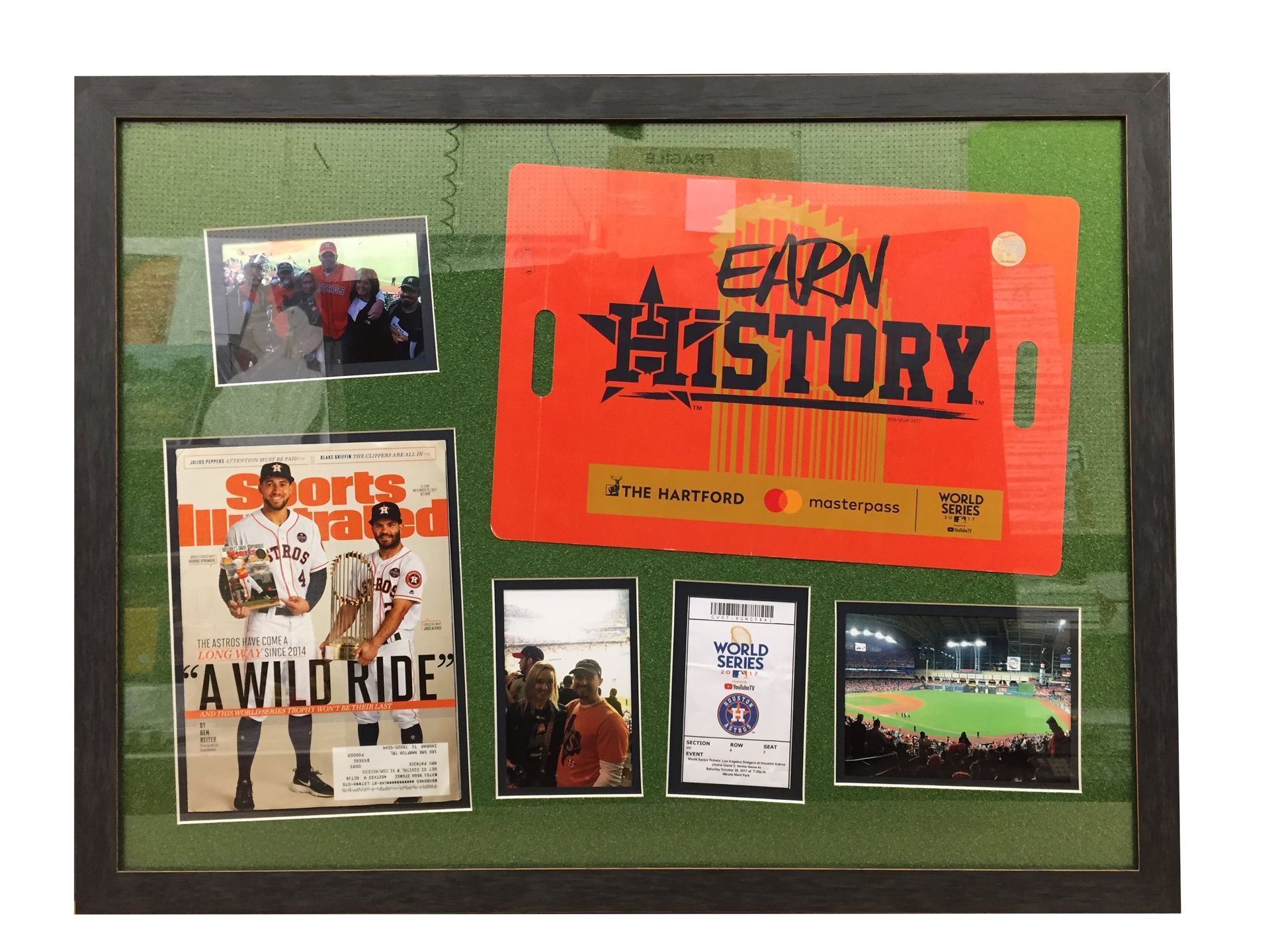 Framed Houston Astros memorabilia: ticket, magazine cover, photos, against a green background.