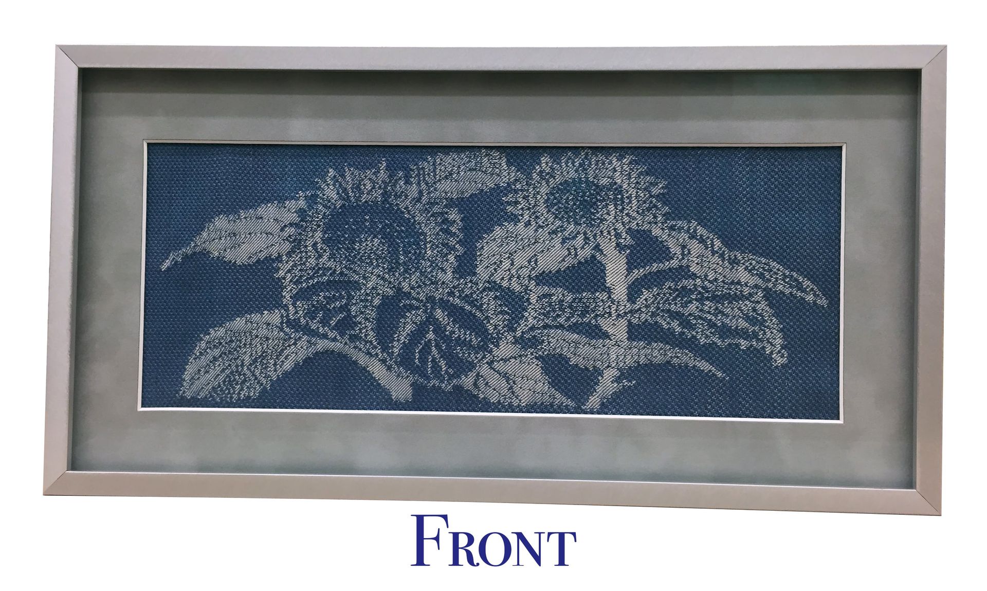 Framed textile art of a plant with white thread on blue fabric.