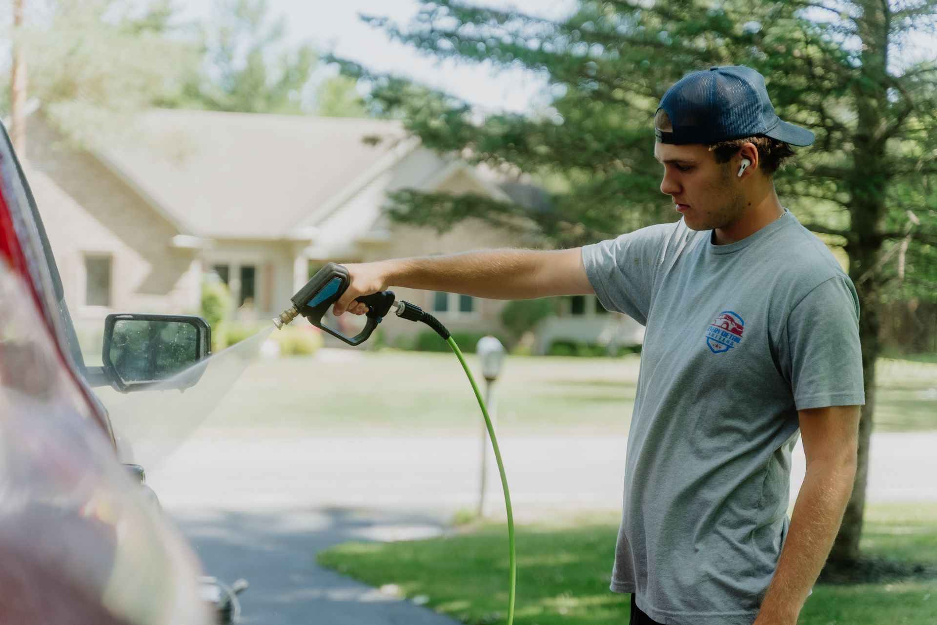 A person is washing a car with a hose.