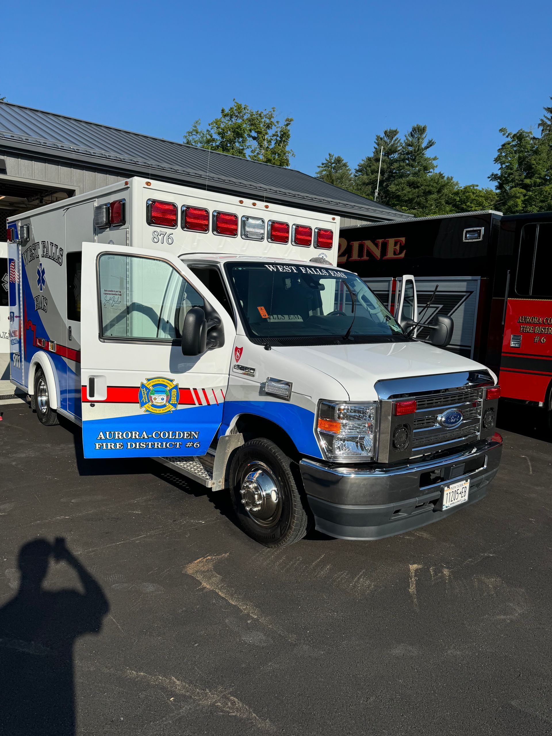 A white and blue ambulance is parked in front of a building.