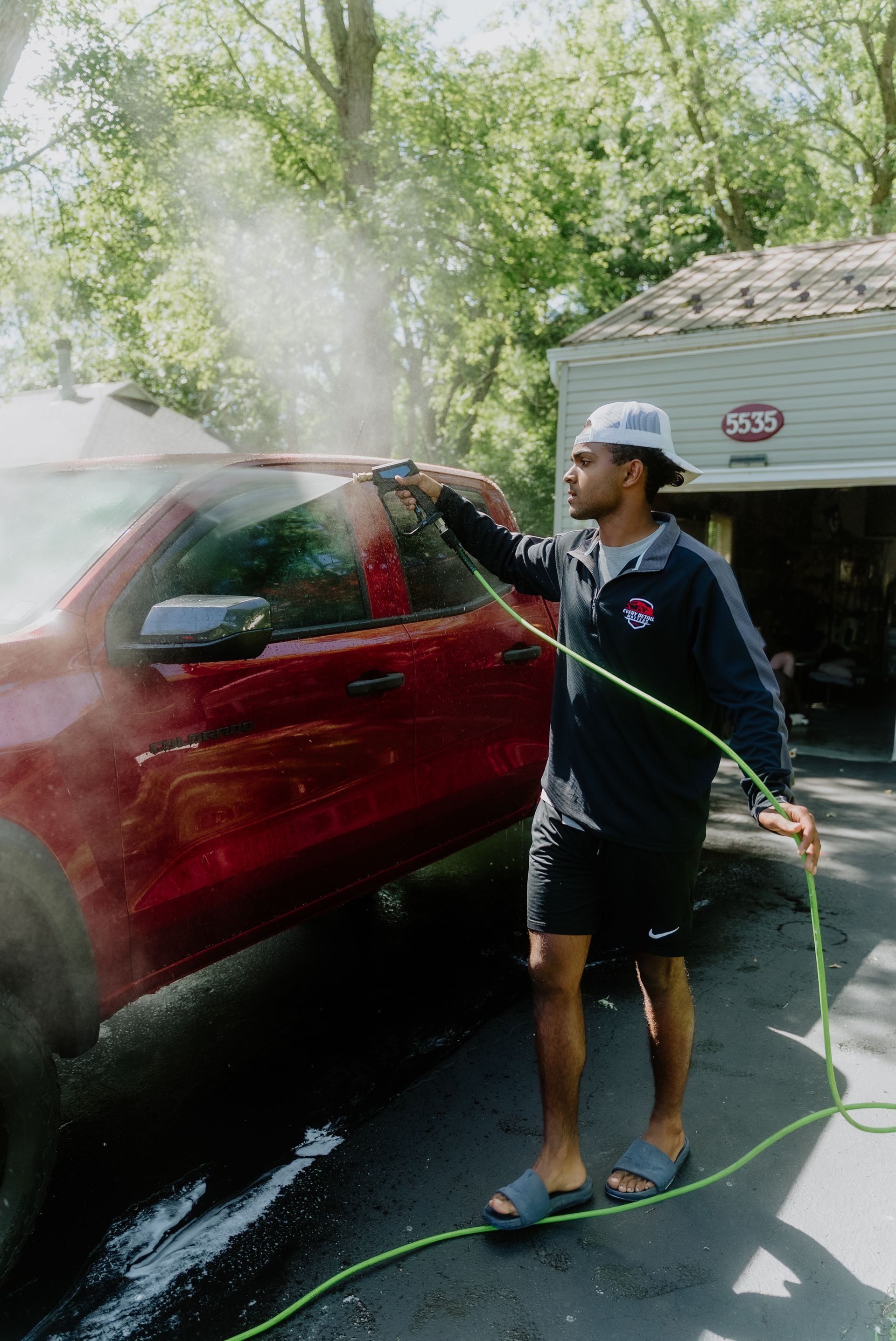 A close up of a car being washed in a garage.