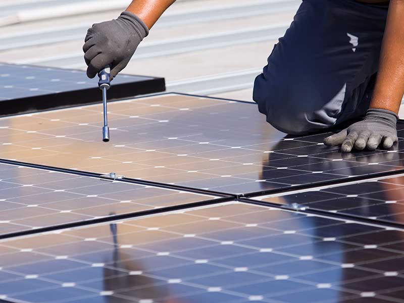 tecnico mentre installa pannelli solari sul tetto