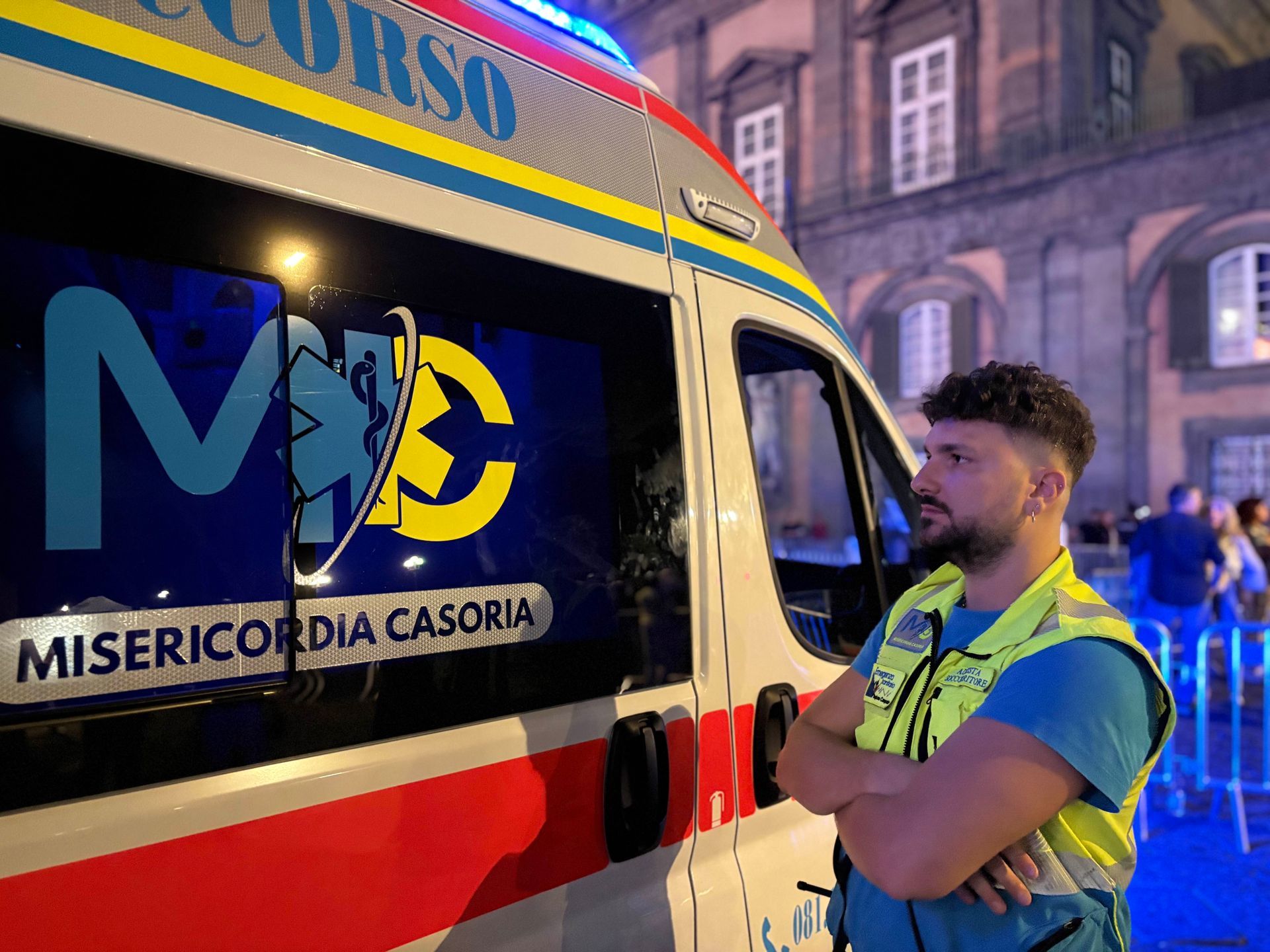 Ambulanza e veicolo di emergenza parcheggiati su una strada cittadina, probabilmente in risposta a una chiamata.