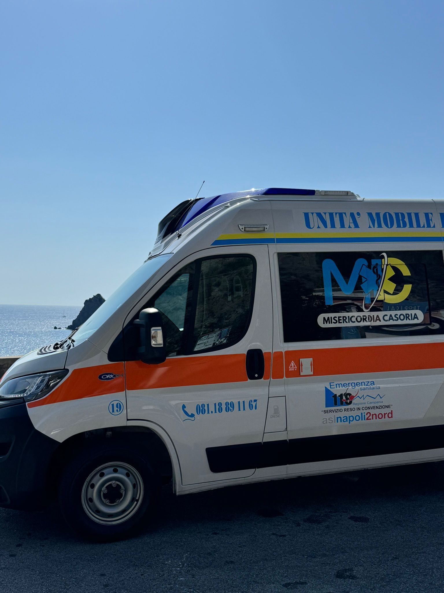 Ambulanza con luci blu lampeggianti e scritta 