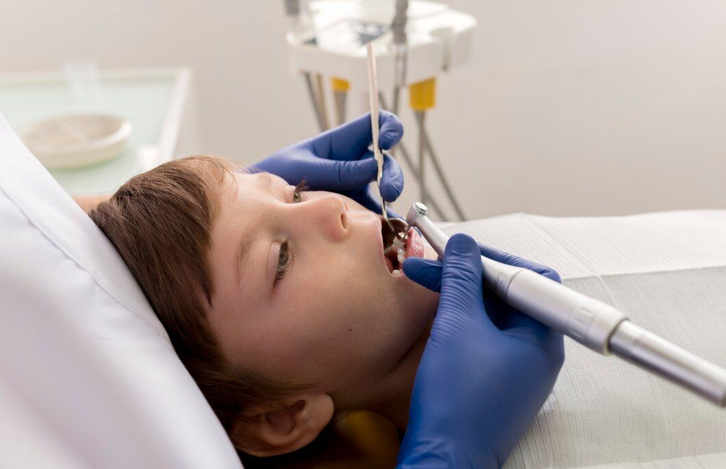 A young boy is getting his teeth examined by a dentist.