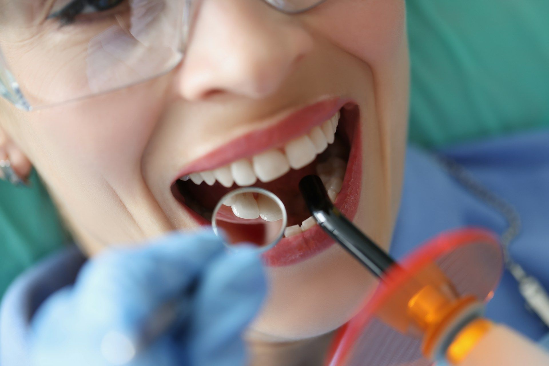 A woman is getting her teeth examined by a dentist.