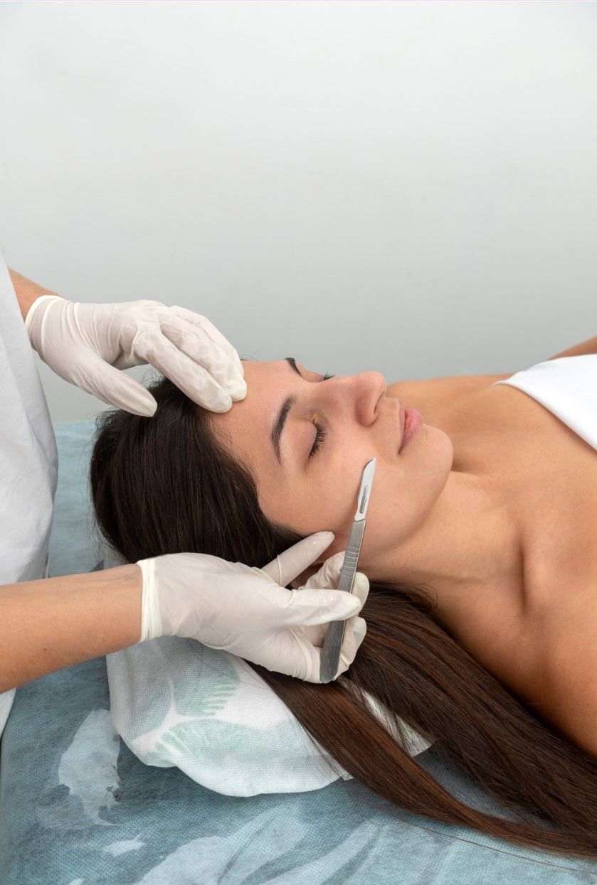 Facial treatment with gloved hands applying a product to a woman’s face in a spa setting