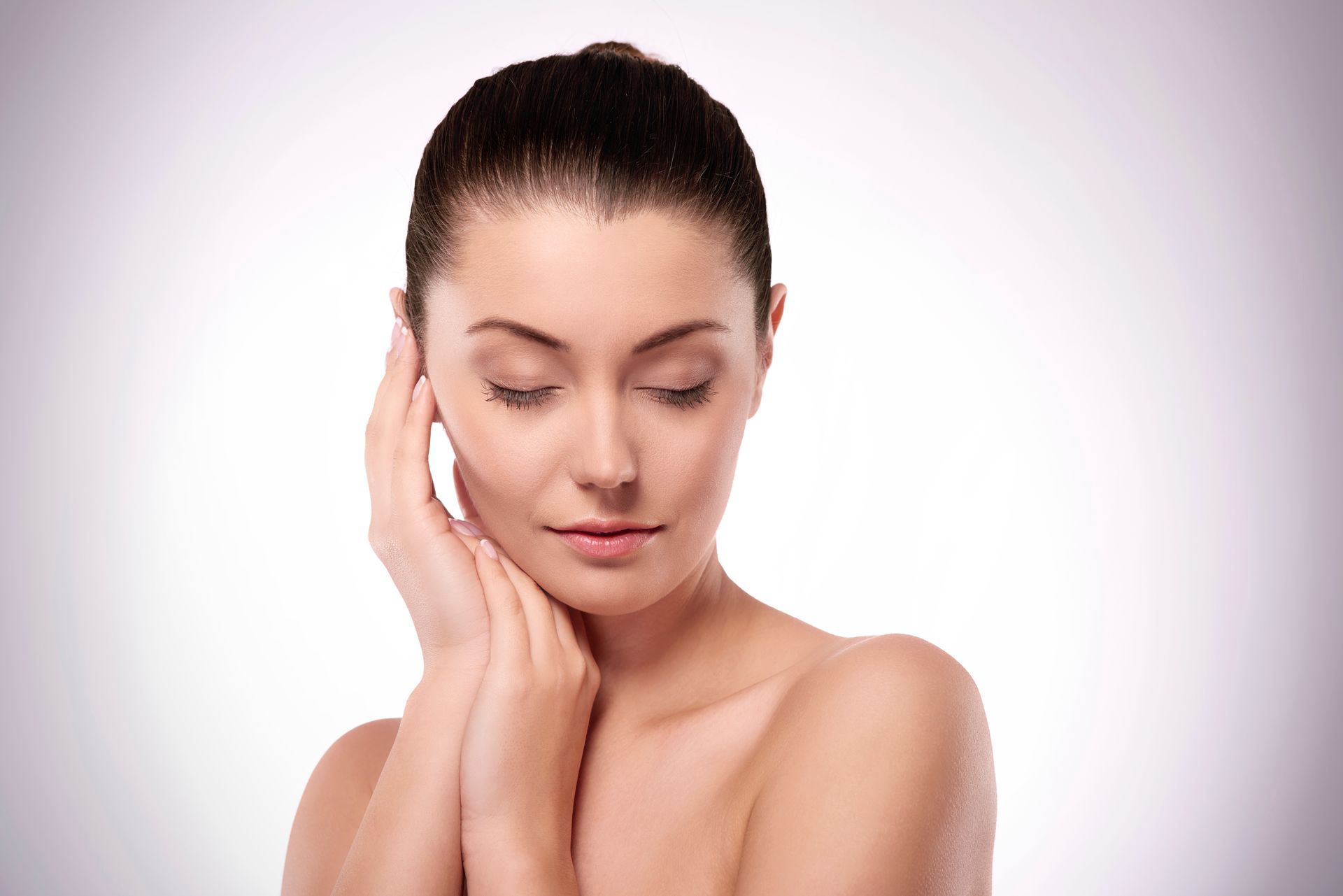 a woman with closed eyes, touching her face