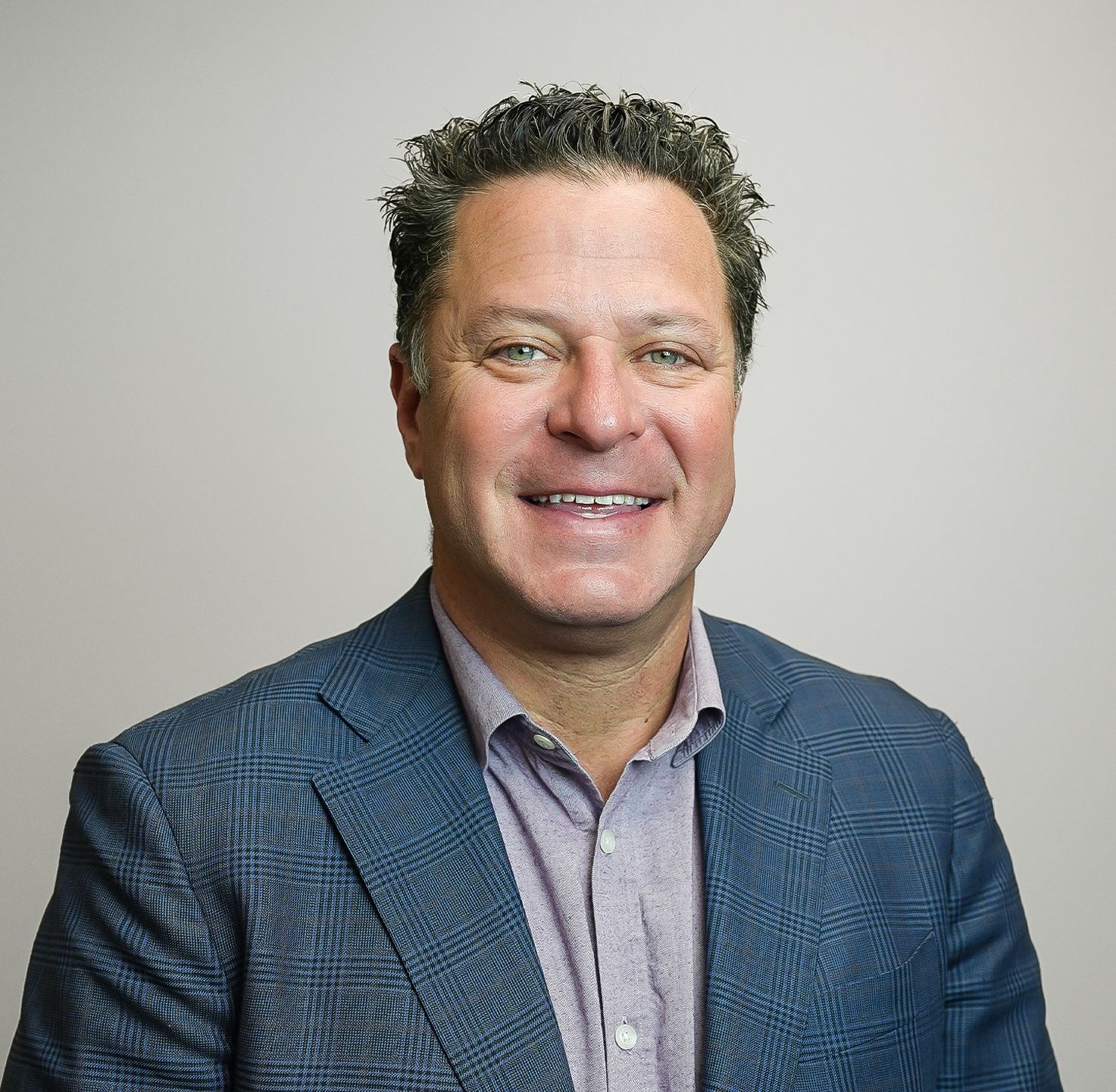 A man and a woman are sitting on a dock overlooking a lake.