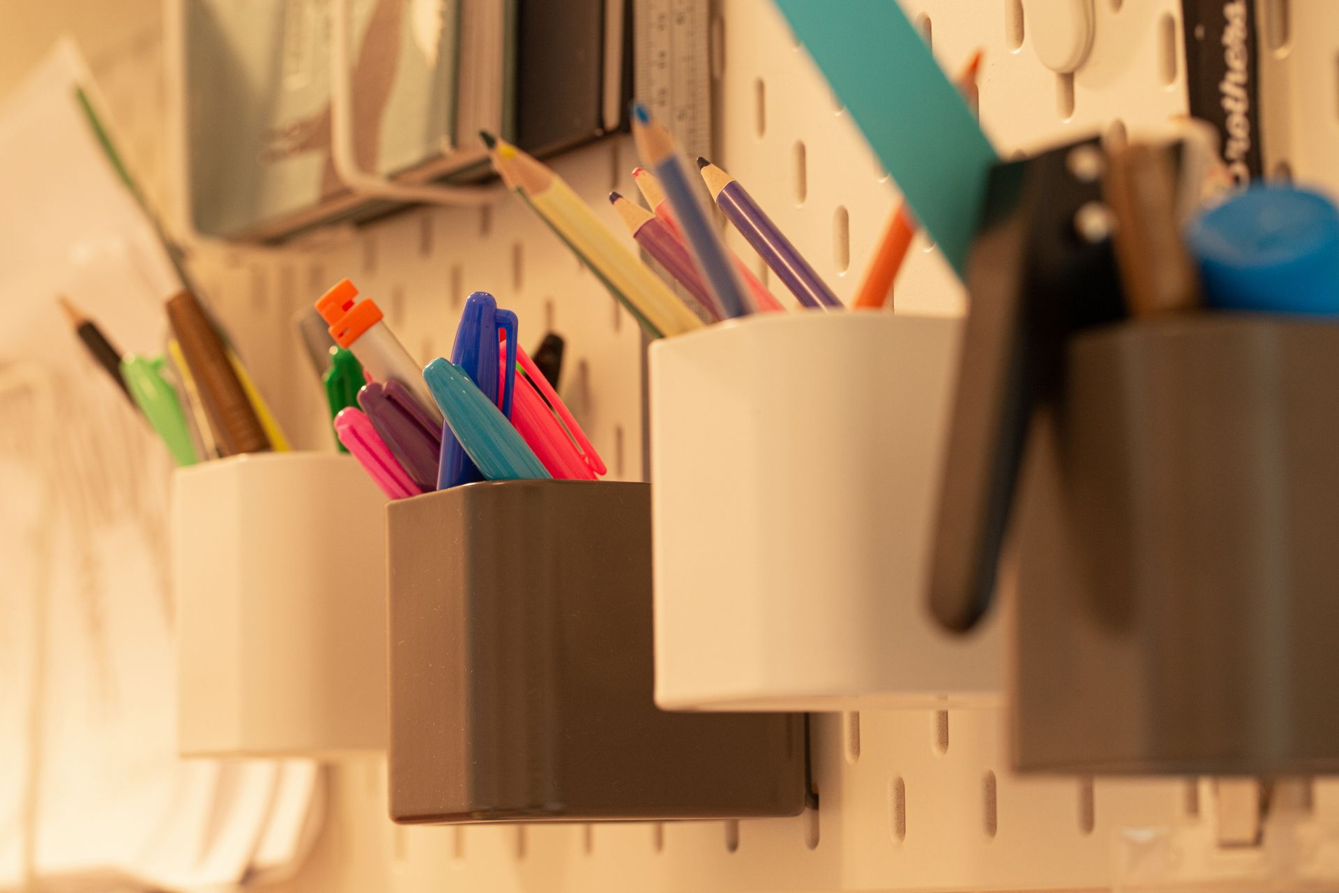 Un mucchio di penne e matite sono appese a una parete.