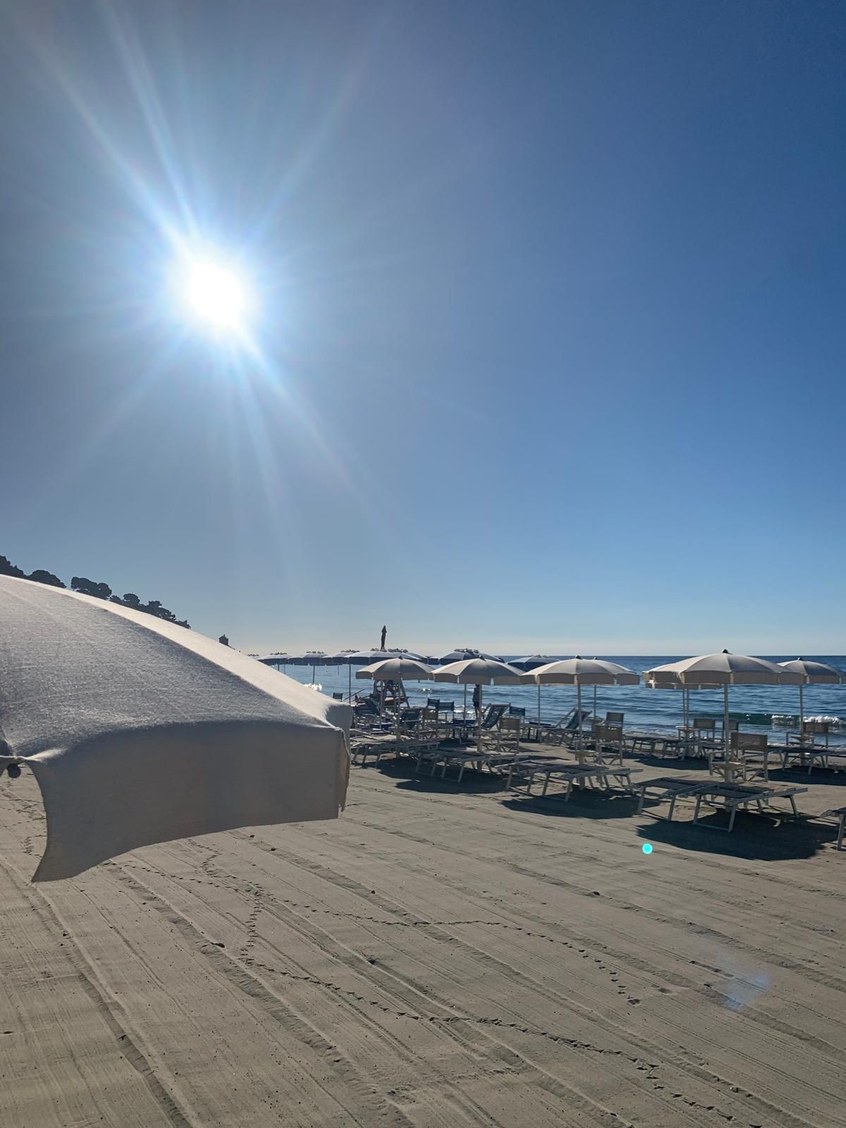 Una spiaggia con ombrelloni e sedie a sdraio in una giornata di sole