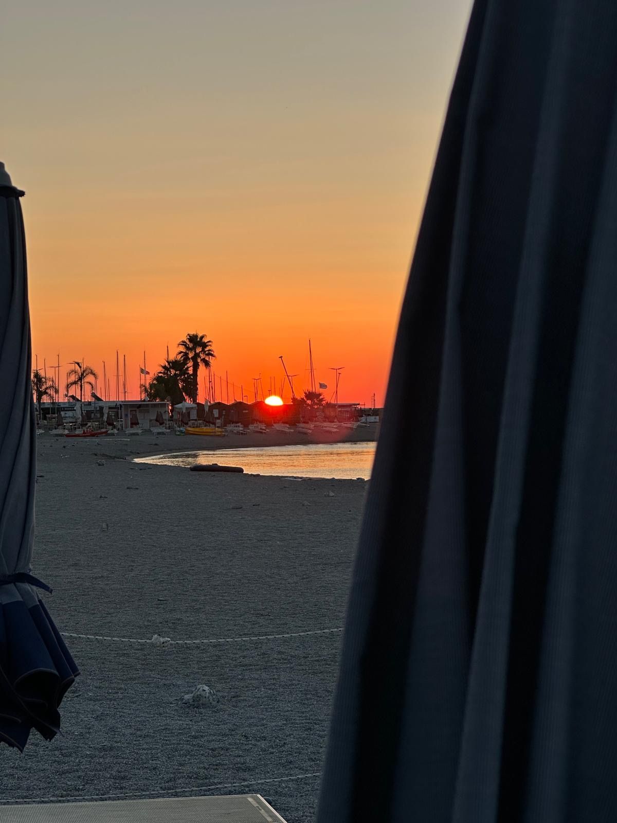 Due uomini sono in piedi su una spiaggia con in mano una cornice di Instagram